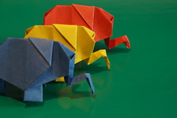 Origami elephant out of paper isolated on a colored background