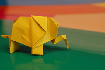 Origami elephant out of paper isolated on a colored background