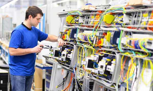 Elektroniker montiert eine Maschine in einer Fabrik // electronics mounted a machine in a factory