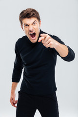 Mad furious young man pointing on you and shouting