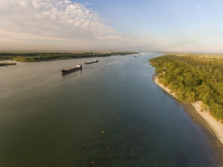 Cargo ship in green river water. Aerial view.