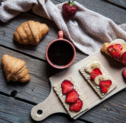 delicious breakfast with a cup of coffee and fruit sandwiches, croissants. Strawberries, food, drink, chocolate.