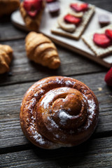delicious breakfast with strawberries and sweet bun on wooden background. Fruit, food, chocolate