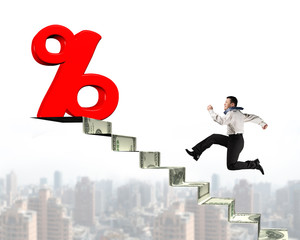 Man running toward percentage sign on top of money stairs