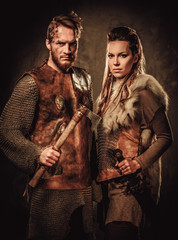 Vikings couple posing in studio on dark background.