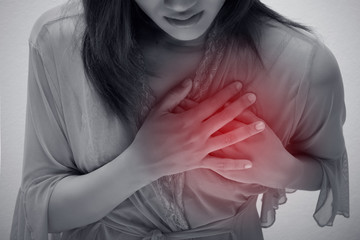 Woman is clutching her chest, acute pain possible heart attack