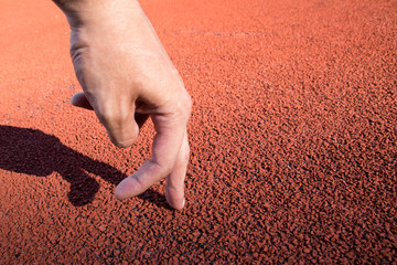 Two fingers man running on running track at sport stadium