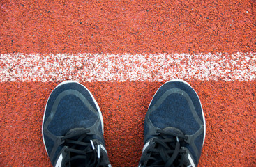 Close up running shoes on running Track White Lines at sport stadium