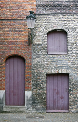 Fototapeta na wymiar closed purple doors and shutters in the old town of bruges in be