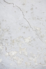 part of old wheathered white stucco full of cracks on outside wa