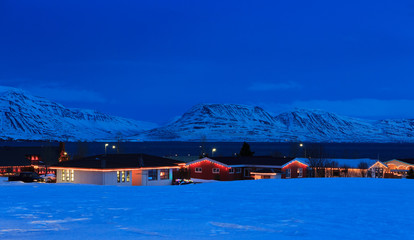 Typical Icelandic houses with Christmas decorations at the twilight near Akureyri, North Iceland.