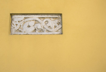 Ancient Roman Bas-relief art in a yellow wall