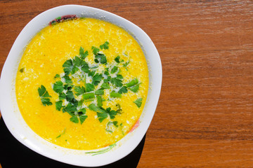 Soup with green parsley on wooden table