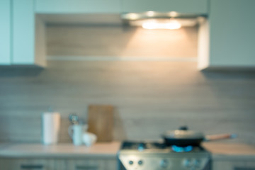 Blurred background. Modern kitchen with cooking on gas and space for you. Toned image.