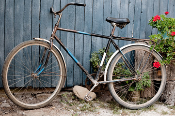 Old  bicycle near a blue wooden fence in village