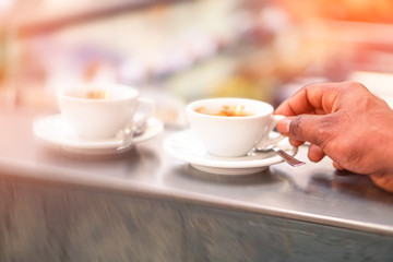 Man drinking coffee cup at bar counter - Male hand holding espresso at cafe shop - Concept of caffeine addiction and people daily habits 