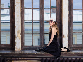 Young woman wearing long black dress and hat