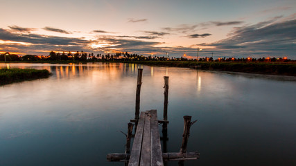 Wooded bridge in the port at sunset.