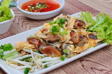 Fried oyster with bean sprouts with chili sauce.Selective focus.