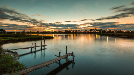 Wooded bridge in the port at sunset.