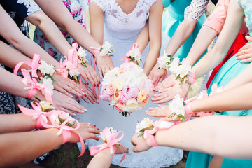 Bride's bouquet in her hands and friends