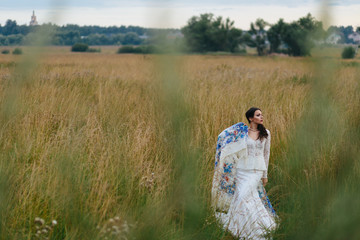 Long shawl wraps a tender brunette in an old-fashioned dress