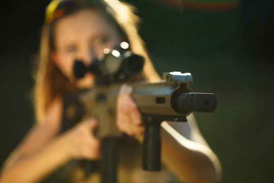 Girl with a gun for trap shooting aiming at a target