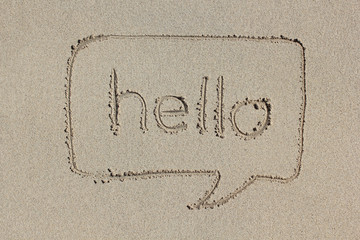 Speech bubble with the word hello written in the sand.