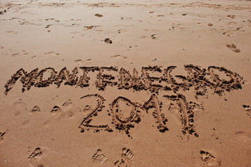 "Montenegro 2017" written in the sand on the beach