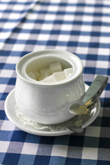 Sugar-bowl with a lump sugar on a table