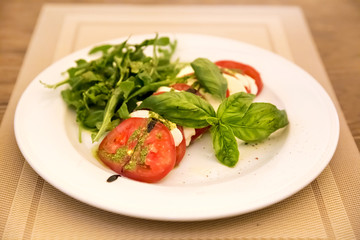 Caprese Salad - salad with tomato, mozzarella cheese and pesto s