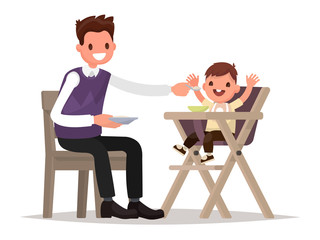 Child Feeding. Father is  feeding baby sitting in the highchair.