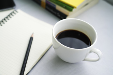 Coffee in white cup with Journal book and pencil