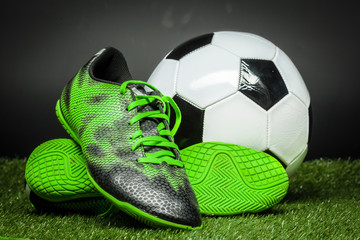 soccer ball and cleats on the football field