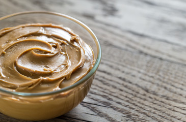 Bowl of peanut butter on the wooden table