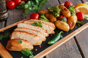 Chicken breast baked with tomato new potatoes and broccoli