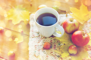 close up of tea cup on table with autumn leaves