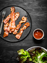 Fried bacon with sauce and greens.