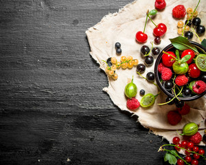Fresh berries in a cup on the old fabric.