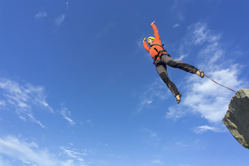 Jump rope from a high rock in the mountains.