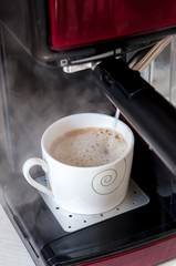 Espresso machine, coffee maker. Preparing coffee.Cup ready to receive coffee.Espresso machine pouring the milk foam. Preparing a latte, pouring milk into cup.