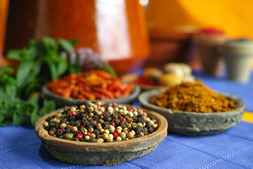 Collection of different spices in old clay bowls in colorful oriental style