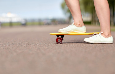 close up of female feet riding short skateboard