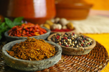 Dried red, hot chili, black, white peppers in old clay bowls in oriental style