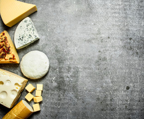Different types of cheese. On stone table.