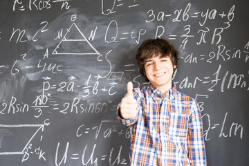 Boy writting on black board