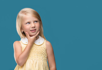 The little girl is thinking about something on a blue background