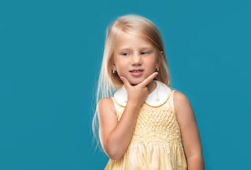 The little girl is thinking about something on a blue background