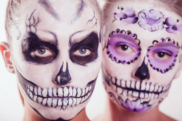Two girls with Halloween face art on white background