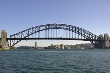 Fototapeta na wymiar small motor boat passing by the Sydney Harbour bridge, Sydney NSW Australia 